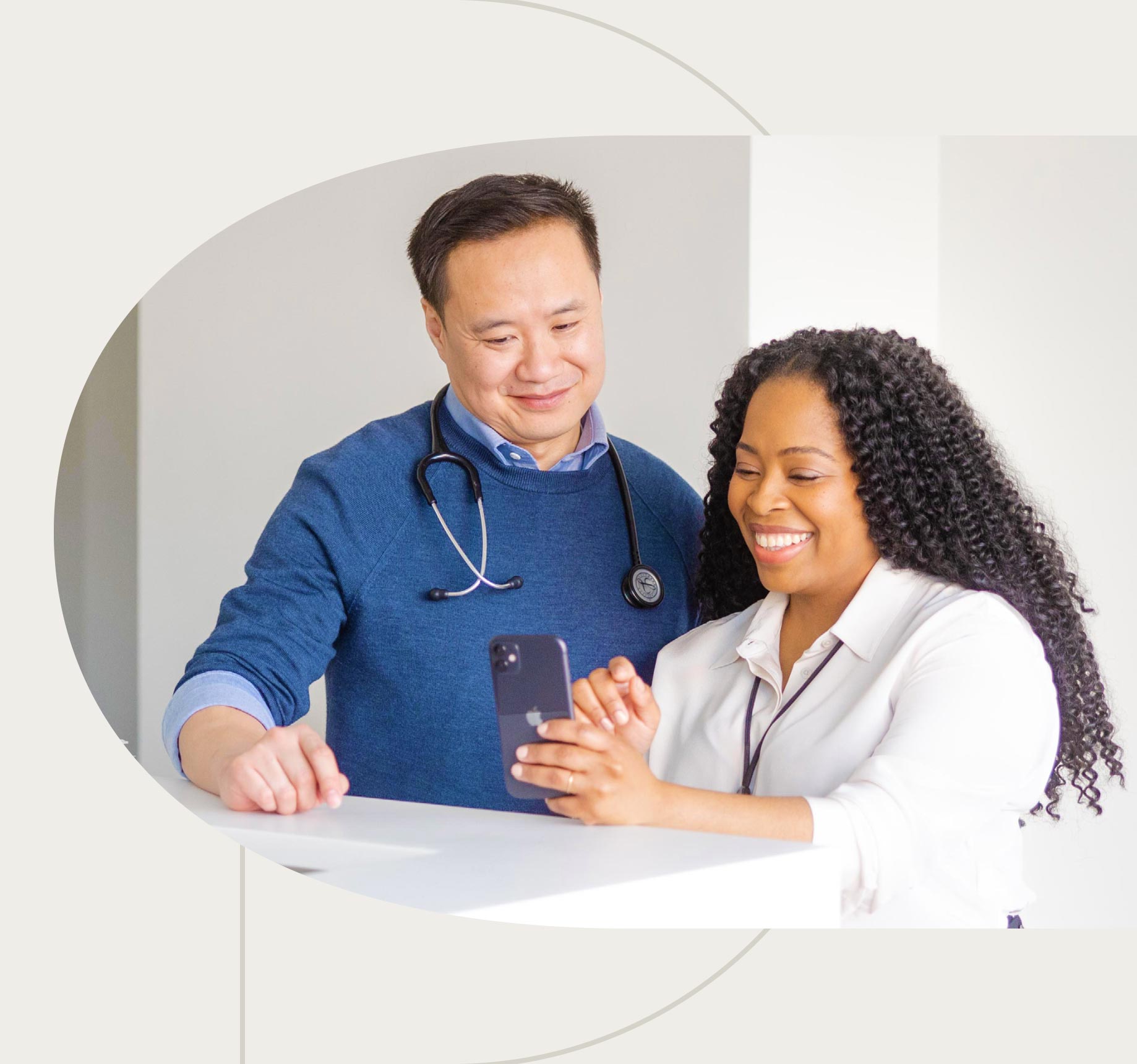 A physician and medical practitioner reviewing patient information on a smart phone.