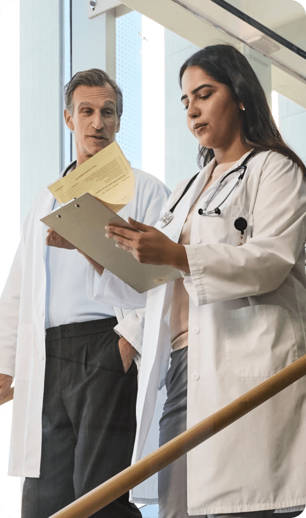 Two physicians analyzing documents at hospital