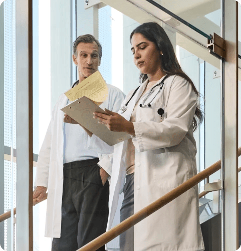Two physicians analyzing documents at hospital