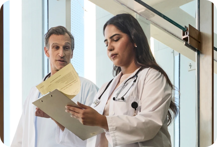 Two physicians analyzing documents at hospital
